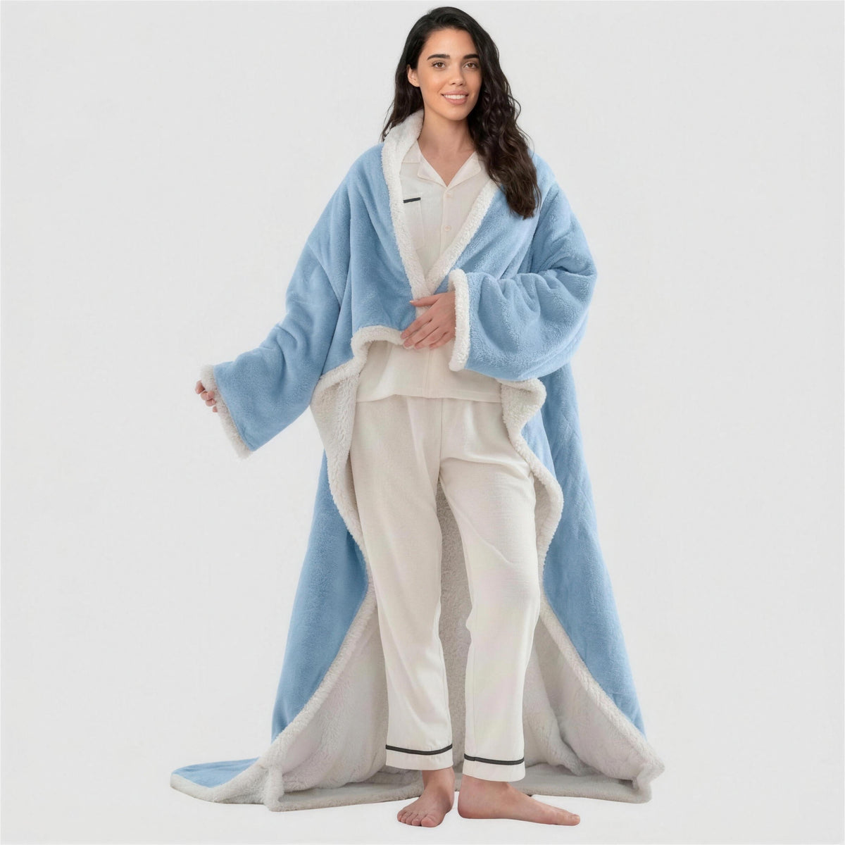 Smiling woman standing in a light blue Kokoon wearable heated blanket
